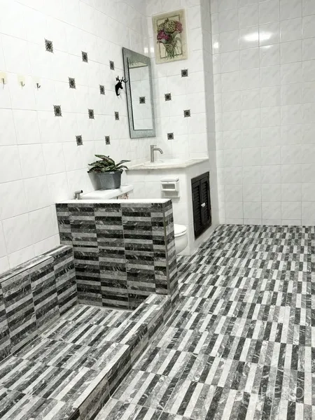 联排别墅 出租在Prawet, Bangkok - 大卫生间，灰色条纹瓷砖与抬高淋浴区。