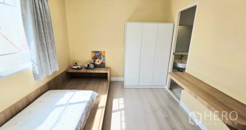 Townhouse for rent in Bang Bo, Samut Prakan - Bedroom with platform bed, wardrobe and door to bathroom.