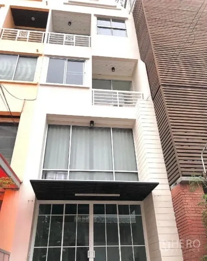 Home Office for rent in Wang Thonglang, Bangkok - Street-side view of a modern townhouse-style home office with tall windows and rail balconies.