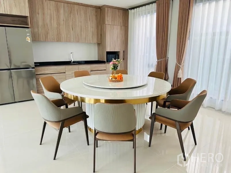 บ้าน ให้เช่าหรือขายในBang Kapi, Bangkok - โซนทานอาหารเชื่อมครัว โต๊ะกลมท็อปหินอ่อน 6 ที่นั่ง ตู้ลายไม้ และผ้าม่านโปร่งเต็มบาน.