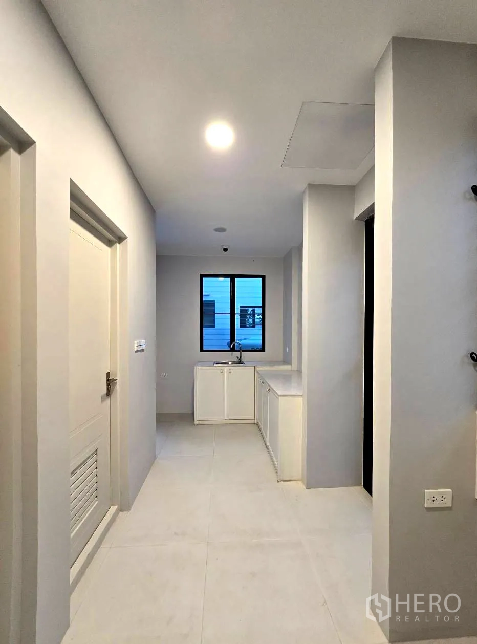 Detached House for rent in Saphan Sung, Bangkok - Thai kitchen with gas cooktop, sink and white cabinets.