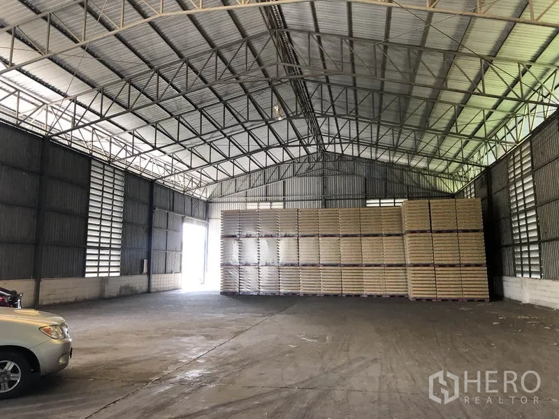 คลังสินค้า ให้เช่าในPathum Thani - ฮอลล์เก็บสินค้าช่วงกว้าง ไม่มีเสากลาง มีกองพาเลทและประตูข้างสว่าง