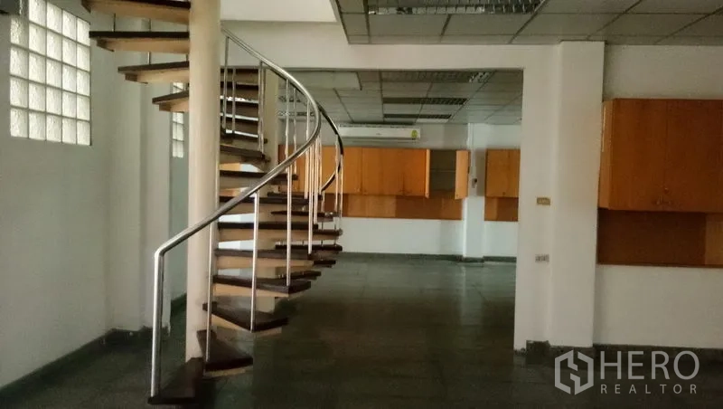 Office Space for rent in Sathon, Bangkok - Spiral staircase connecting office levels beside a glass-block feature wall.