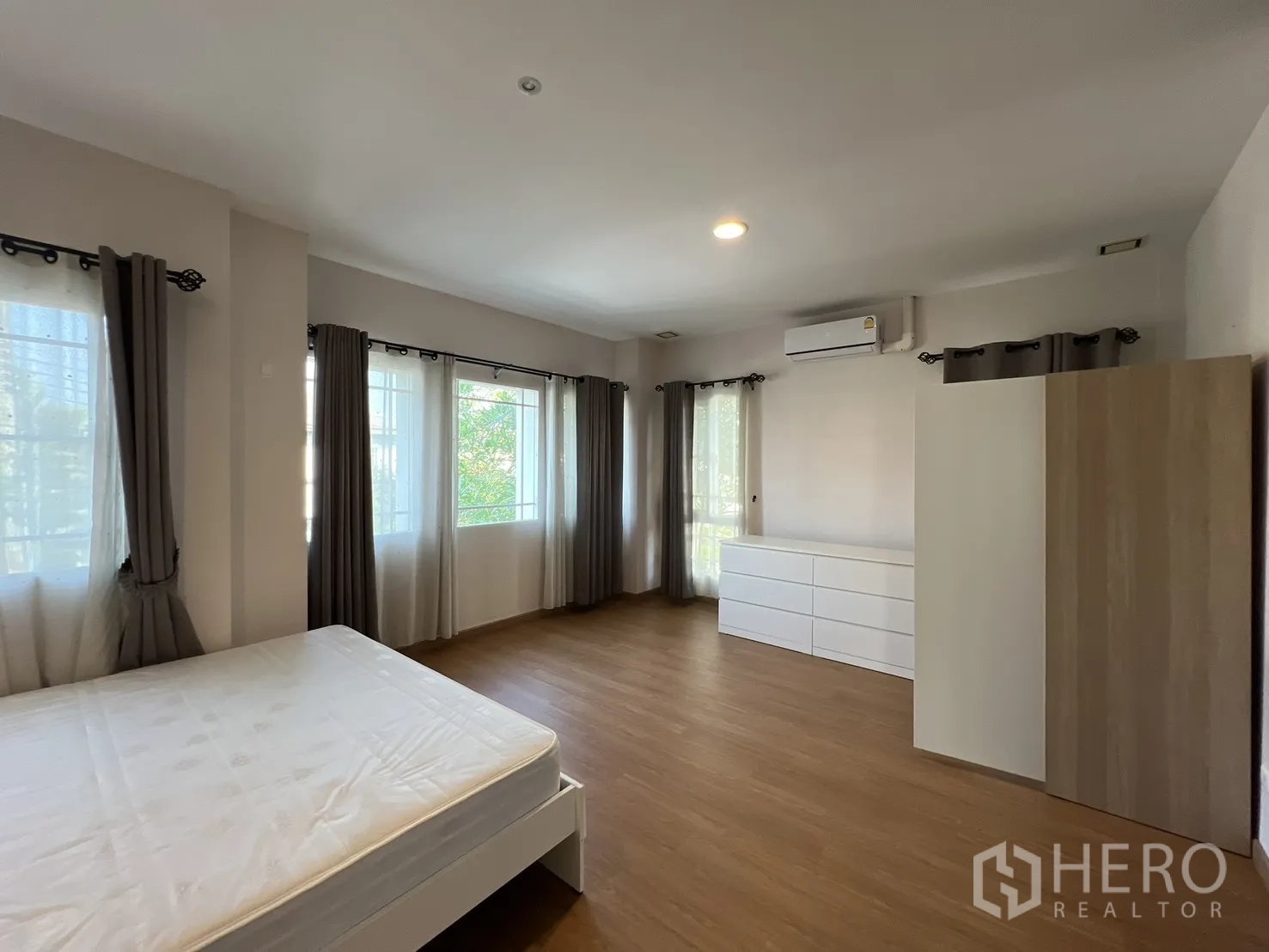 บ้านเดี่ยว for rent in Bang Kapi, Bangkok - ห้องนอนมุมกว้างพื้นไม้พร้อมหน้าต่างหลายด้านสว่างโปร่ง.