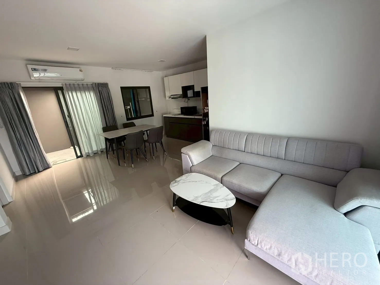 Townhouse for rent in Bang Phli, Samut Prakan - L-shaped sofa with marble coffee table in a bright living room.