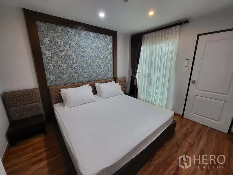 Condominium for rent in Phra Khanong, Bangkok - Second bedroom with large bed, floor-to-ceiling window, and sheer curtains.