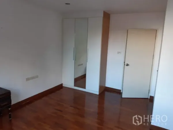 คอนโด ขายในWatthana, Bangkok - มุมห้องนอนมีตู้เสื้อผ้าบานกระจกสีขาวและพื้นไม้ขัดเงา