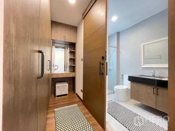 Detached House for rent in Bang Rak, Bangkok - Walk-in wardrobe with vanity leading to a modern bathroom with shower.