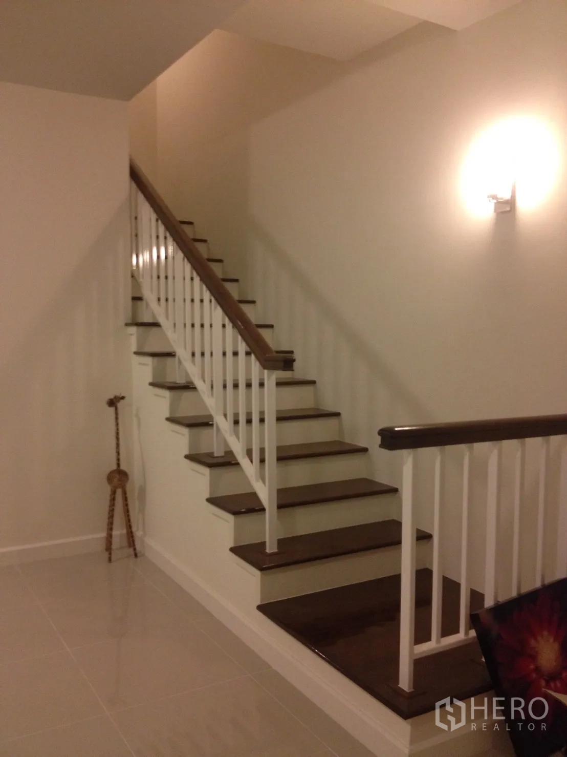 联排别墅 出租在Watthana, Bangkok - 木质楼梯配白色扶手，走廊光线柔和。