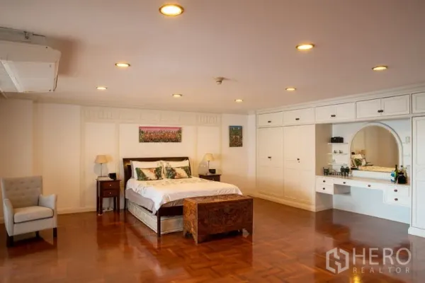 คอนโด ให้เช่าในKhlong Toei, Bangkok - ห้องนอนมาสเตอร์กว้างขวาง มีไฟดาวน์ไลท์ ตู้เสื้อผ้าบิวท์อินสีขาว โต๊ะเครื่องแป้ง และพื้นไม้