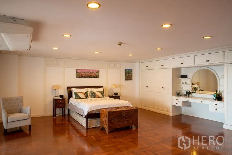 คอนโด ให้เช่าในKhlong Toei, Bangkok - ห้องนอนมาสเตอร์กว้างขวาง มีไฟดาวน์ไลท์ ตู้เสื้อผ้าบิวท์อินสีขาว โต๊ะเครื่องแป้ง และพื้นไม้