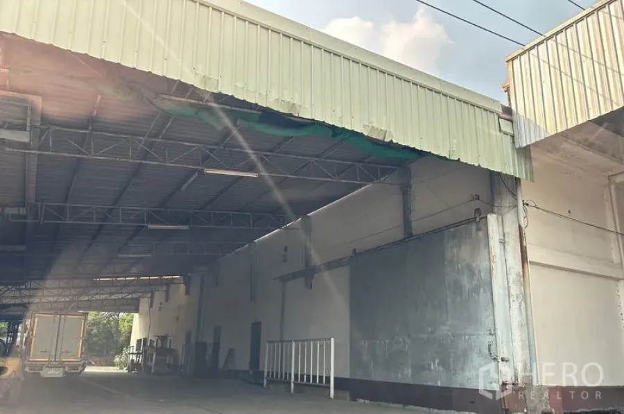 Warehouse for rent in Lat Krabang, Bangkok - Covered loading bay with high metal roof and wide truck access at a Lat Krabang warehouse.