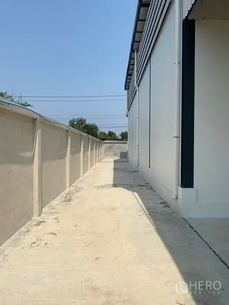 คลังสินค้า ให้เช่าในBang Kruai, Nonthaburi - ทางสัญจรรอบอาคารคอนกรีตขนานกำแพงรั้วสูงของโกดัง