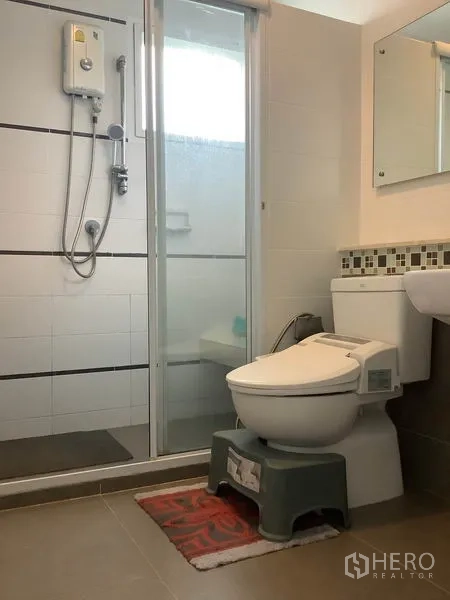 Detached House for rent in Bang Kapi, Bangkok - Bathroom with glass shower enclosure, water heater, vanity mirror and toilet.