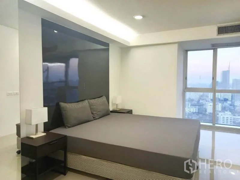 公寓 出租在Khlong Toei, Bangkok - 卧室落地窗可欣赏曼谷天际线黄昏景观。