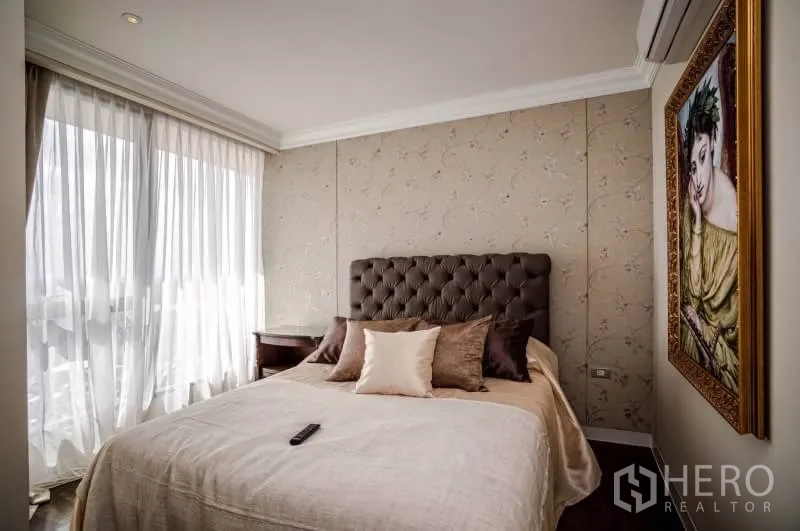 Condominium for rent or sale in Khlong Toei, Bangkok - Third bedroom with tufted headboard, soft wallpaper and large windows.