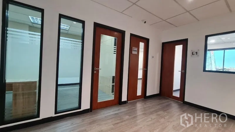 Office Space for rent in Watthana, Bangkok - Entrance area with multiple glass-panel doors to individual rooms along the corridor.
