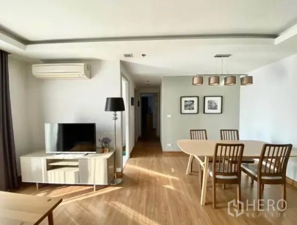 คอนโด ให้เช่าในHuai Khwang, Bangkok - โซนรับแขกและทานอาหารแบบเปิดโล่ง มีทีวี โคมไฟตั้งพื้น และโถงทางเดินสู่ห้องนอน