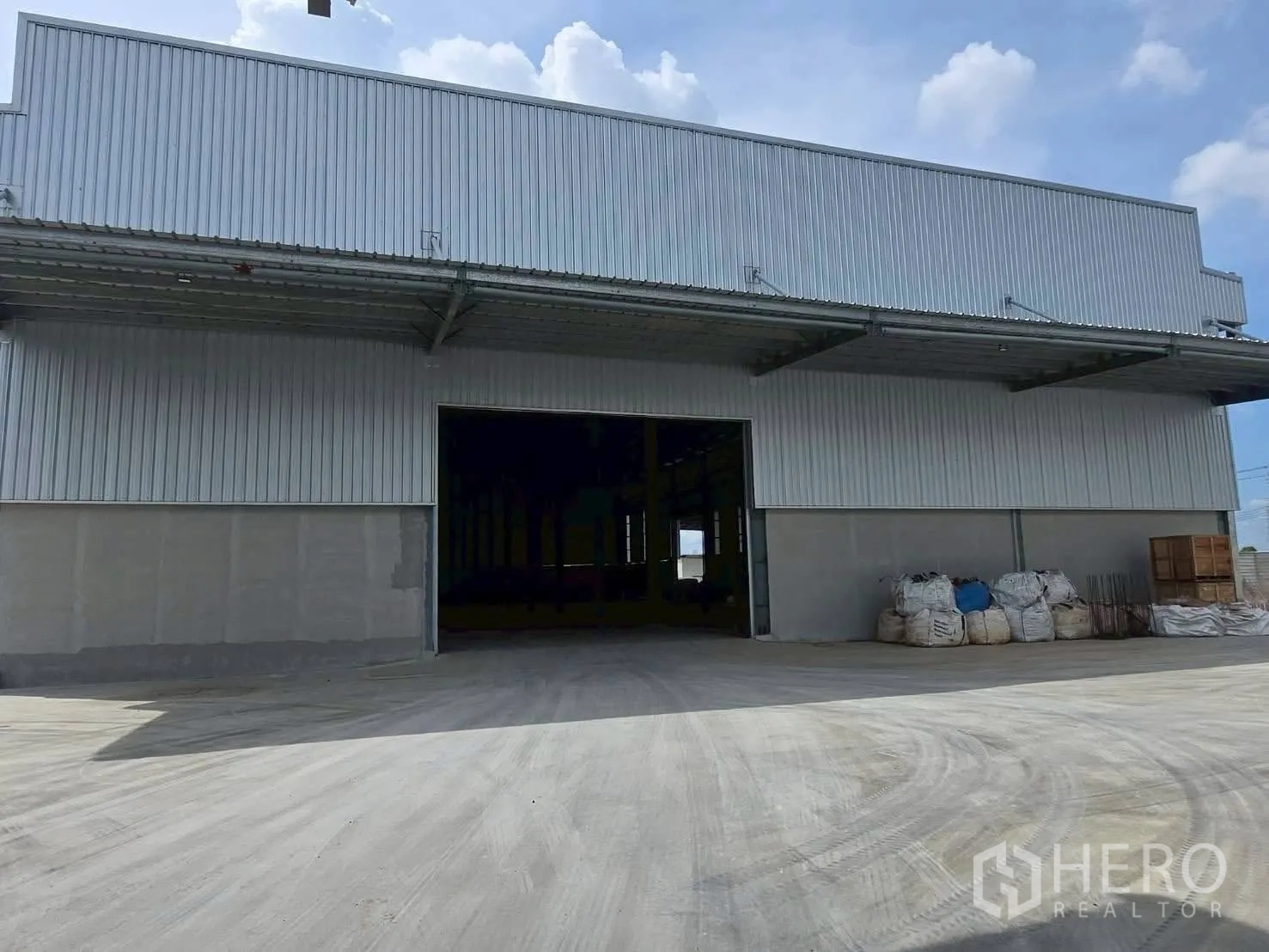 Warehouse for rent in Bang Bo, Samut Prakan - Metal-clad warehouse exterior with large loading door and deep canopy.