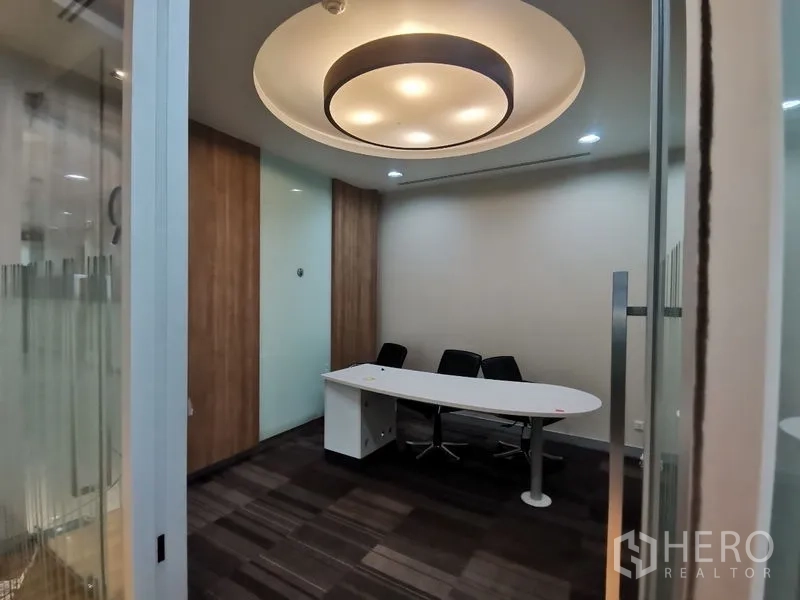 Office Space for rent in Bang Rak, Bangkok - Compact meeting room with circular ceiling light, white desk and three chairs.