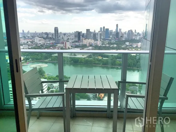 คอนโด ให้เช่าในKhlong Toei, Bangkok - ระเบียงชั้นสูงพร้อมโต๊ะเก้าอี้ มองเห็นวิวทะเลสาบสวนเบญจกิติและสกายไลน์กรุงเทพฯ