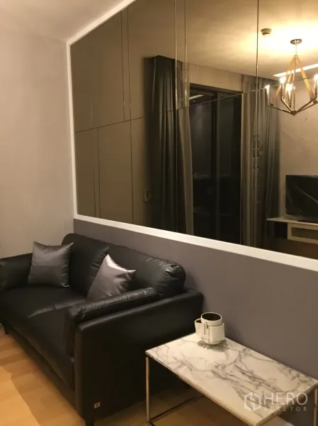 คอนโด ให้เช่าในChatuchak, Bangkok - มุมนั่งเล่นโซฟาหนังสีดำ โต๊ะหินอ่อน และผนังบานกระจก