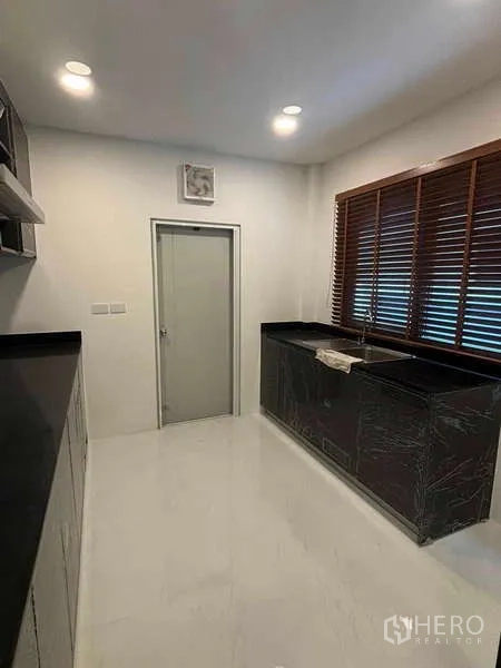 บ้าน ให้เช่าในMueang Nonthaburi, Nonthaburi - ครัวปิดเคาน์เตอร์หินสีดำ มู่ลี่หน้าต่าง และตู้เก็บของจำนวนมาก