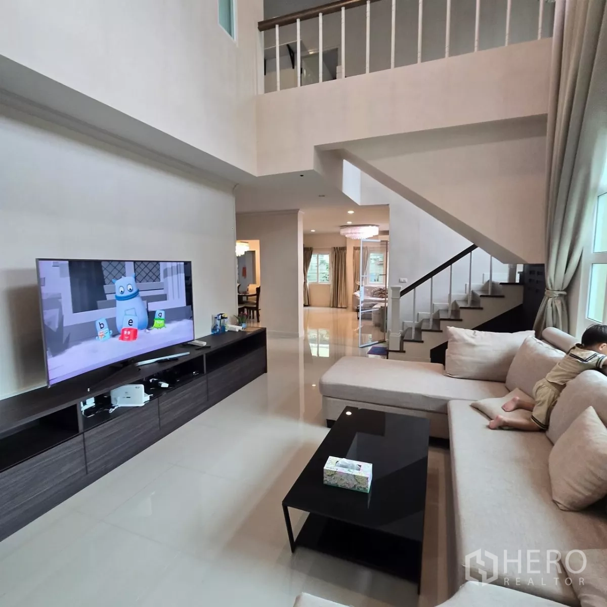 บ้าน ให้เช่าในMueang Pathum Thani, Pathum Thani - ห้องนั่งเล่นโซฟา L ผนังทีวี และมุมบันได