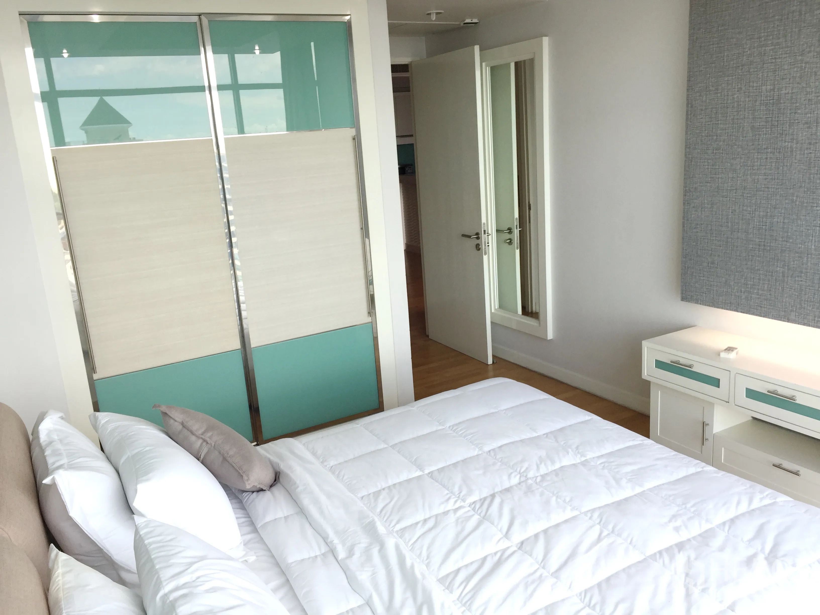 公寓 出租或出售在Sathon, Bangkok - 明亮卧室，滑门衣柜、床侧收纳柜与浅色木地板。