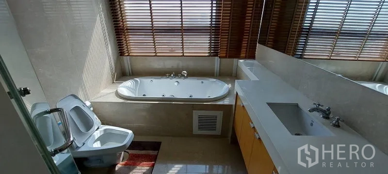 คอนโด ให้เช่าในPathum Wan, Bangkok - ห้องน้ำทันสมัย มีอ่างอาบน้ำข้างหน้าต่าง ม่านไม้ โต๊ะอ่างล้างหน้ายาว กระจกบานใหญ่ โถสุขภัณฑ์และบิเดต์