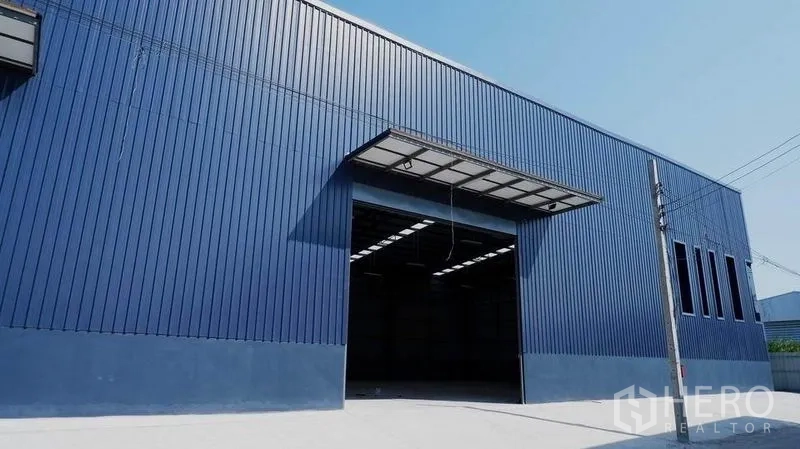 货栈 出租在Bueng Kum, Bangkok - 蓝色金属外墙的仓库外观，宽阔装卸入口与雨棚。