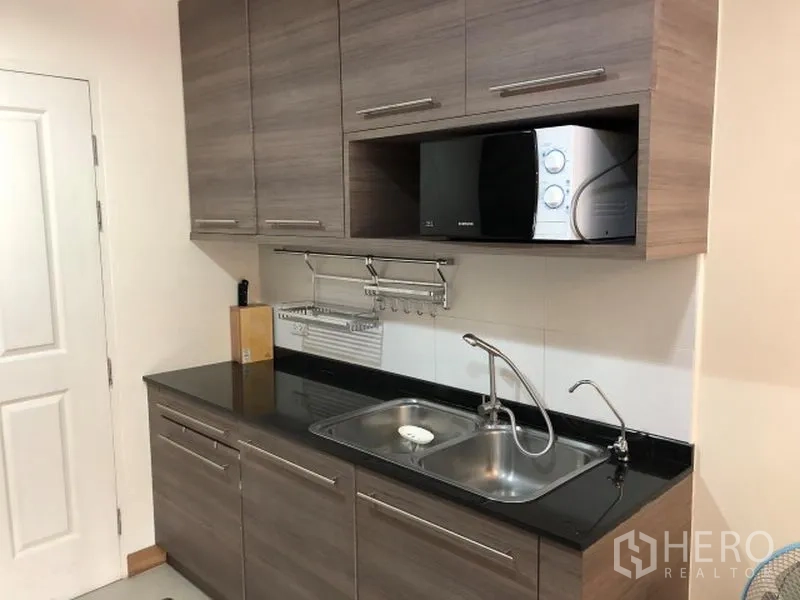 คอนโด ให้เช่าในKhlong Toei, Bangkok - มุมครัวบิวท์อินตู้ไม้ ท็อปสีดำ อ่างล้างจานสองหลุม และไมโครเวฟ