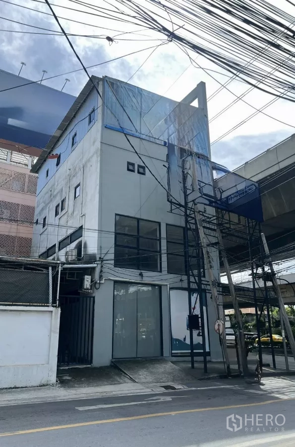 อาคารพาณิชย์ ให้เช่าในHuai Khwang, Bangkok - ภาพด้านหน้าตึกแถว 4 ชั้นติดถนนพระราม 9 เขตห้วยขวาง กระจกบานใหญ่และโครงป้าย.