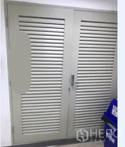 办公空间 出租在Khlong Toei, Bangkok - 走廊的百叶设备门，旁放置回收箱。