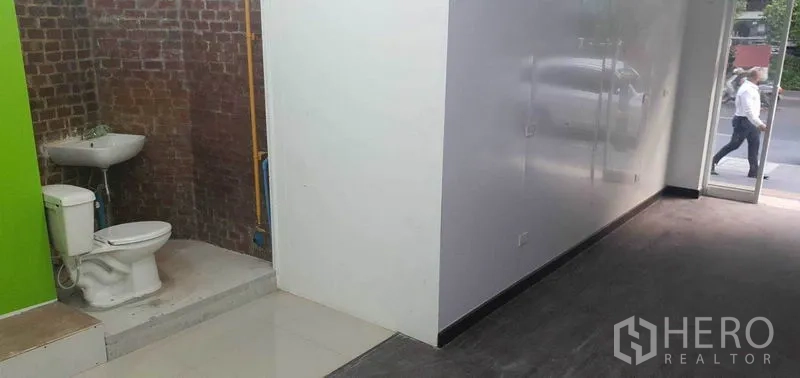 พื้นที่ขายปลีก ให้เช่าในKhlong Toei, Bangkok - มุมพื้นที่โชว์ผนังอิฐพร้อมอ่างล้างหน้าและห้องน้ำติดกับโซนขาย