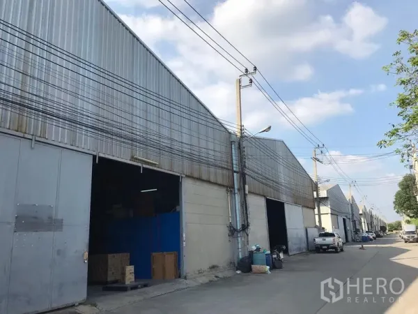 货栈 出租在Bang Phli, Samut Prakan - 沿内部道路排列的多座仓库，装卸开口与电线杆一字排开。