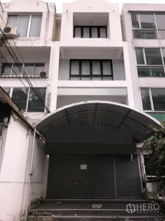 ทาวน์เฮาส์ ขายในWatthana, Bangkok - ด้านหน้าทาวน์เฮ้าส์สีขาวสูง 4 ชั้น เขตวัฒนา กรุงเทพฯ พร้อมประตูม้วนและกันสาดเมทัลชีทโค้ง