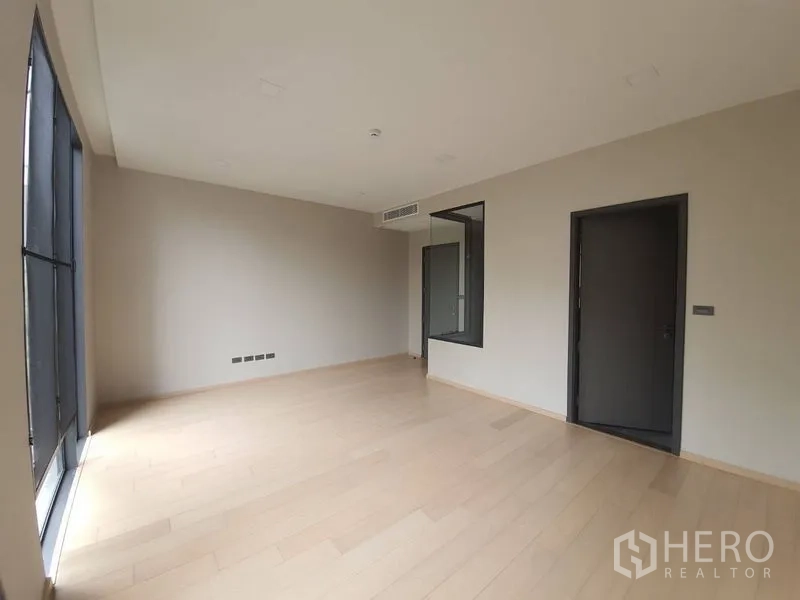 Condominium for sale in Huai Khwang, Bangkok - Alternate view of the master bedroom showing large windows and door to the ensuite bathroom.