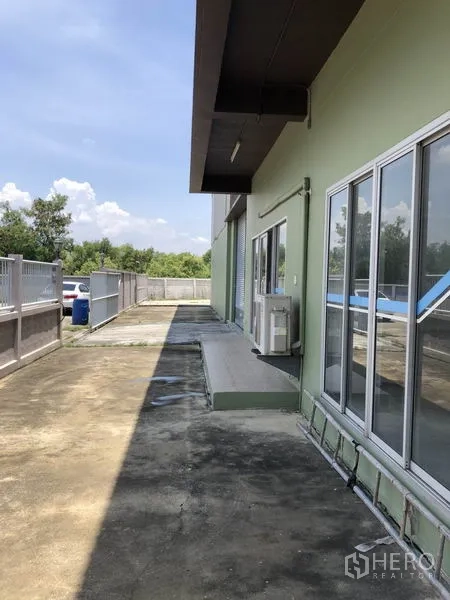 工厂 出租在Pathum Thani - 建筑侧边通道，带推拉玻璃门与空调外机