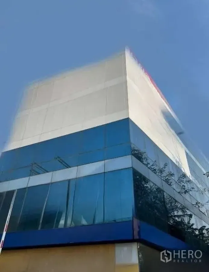 办公空间 出售 - 拍耶泰现代多层办公楼，蓝色玻璃幕墙外立面，晴空背景，靠近BTS Ari。