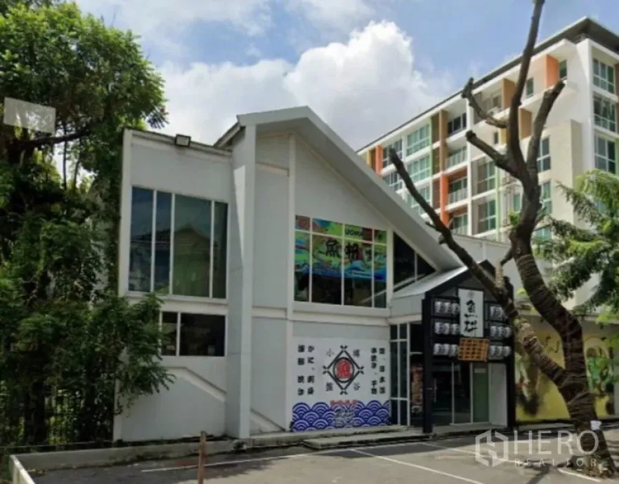 พื้นที่ขายปลีก ให้เช่าในWatthana, Bangkok - ภาพด้านหน้าตึกรีเทลสูง 2 ชั้น แบบอาคารเดี่ยว มีผนังกระจกและที่จอดรถ