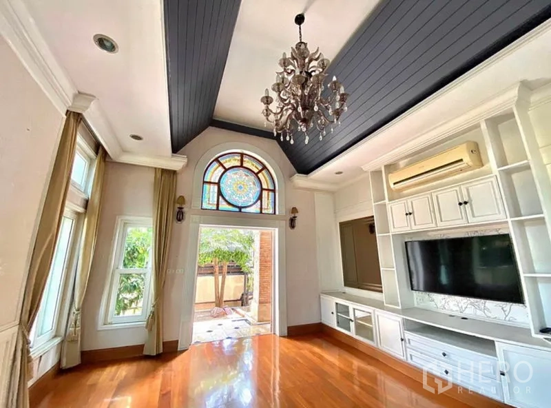 Home Office for rent in Pak Kret, Nonthaburi - Living room with polished wood floors, built-in storage and decorative glass door.