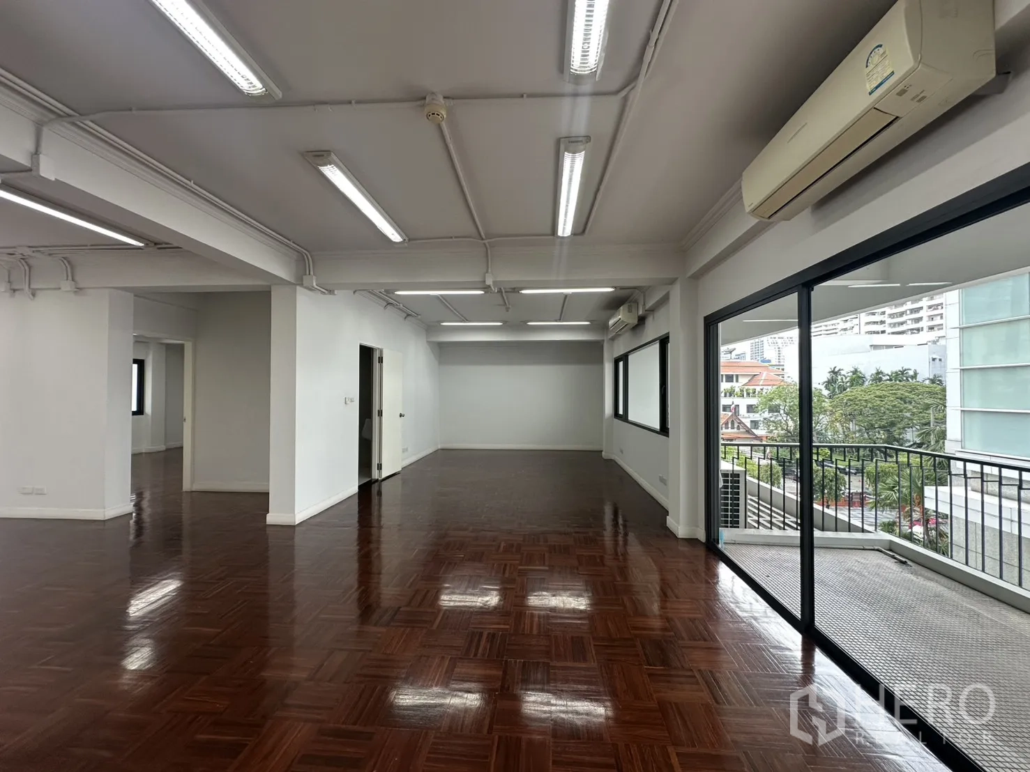办公室 for rent in Watthana, Bangkok - 明亮工作区，壁挂空调与大窗户，连接阳台。