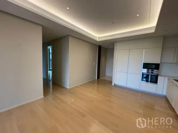 Condominium for rent or sale in Pathum Wan, Bangkok - Spacious living-dining area with minimalist cabinetry and integrated appliances.