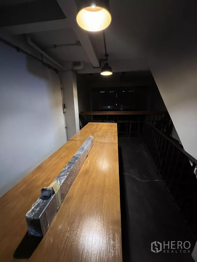 店屋 出租在Watthana, Bangkok - 夹层走道上的长木吧台与吊灯。