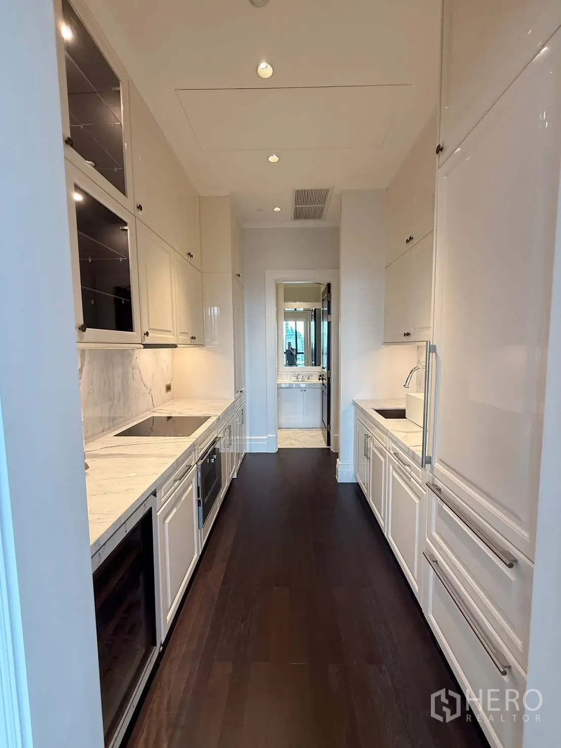 公寓 for rent or sale in Pathum Wan, Bangkok - 走廊式厨房，白色橱柜与大理石台面，内置家电。