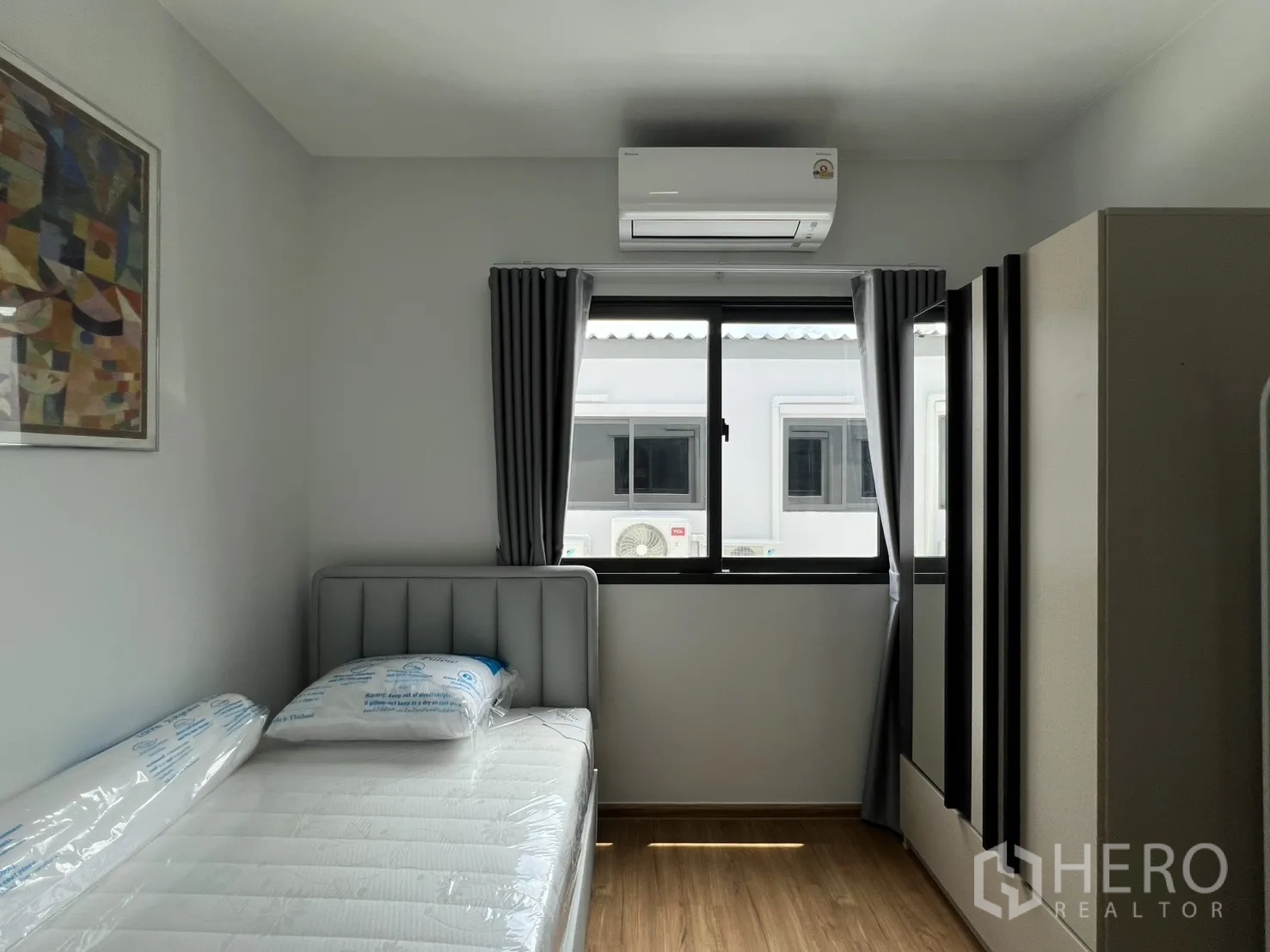 Townhouse for rent in Bang Phli, Samut Prakan - Single bedroom with large window, wardrobe, and wood flooring.