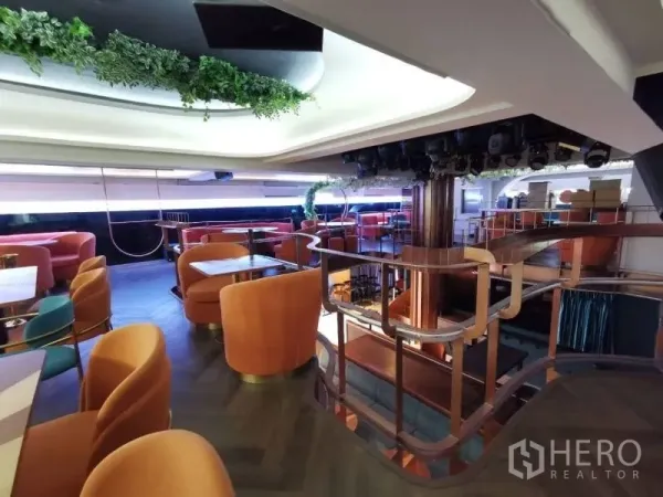 พื้นที่ขายปลีก ให้เช่า - บันไดและราวโค้งขึ้นสู่ชั้นลอยประดับต้นไม้พร้อมที่นั่งเลานจ์