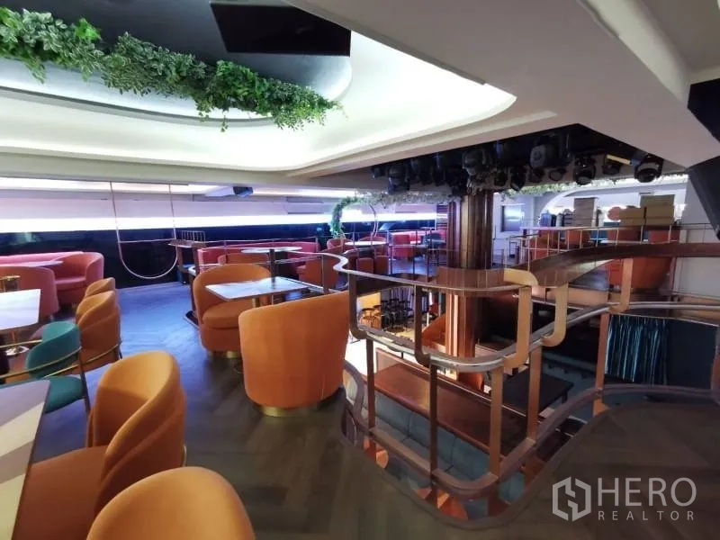 พื้นที่ขายปลีก ให้เช่า - บันไดและราวโค้งขึ้นสู่ชั้นลอยประดับต้นไม้พร้อมที่นั่งเลานจ์