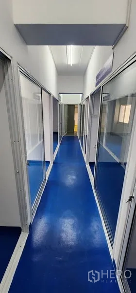 货栈 出租在Bueng Kum, Bangkok - 长走廊，荧光灯照明，左右两侧为玻璃房间。